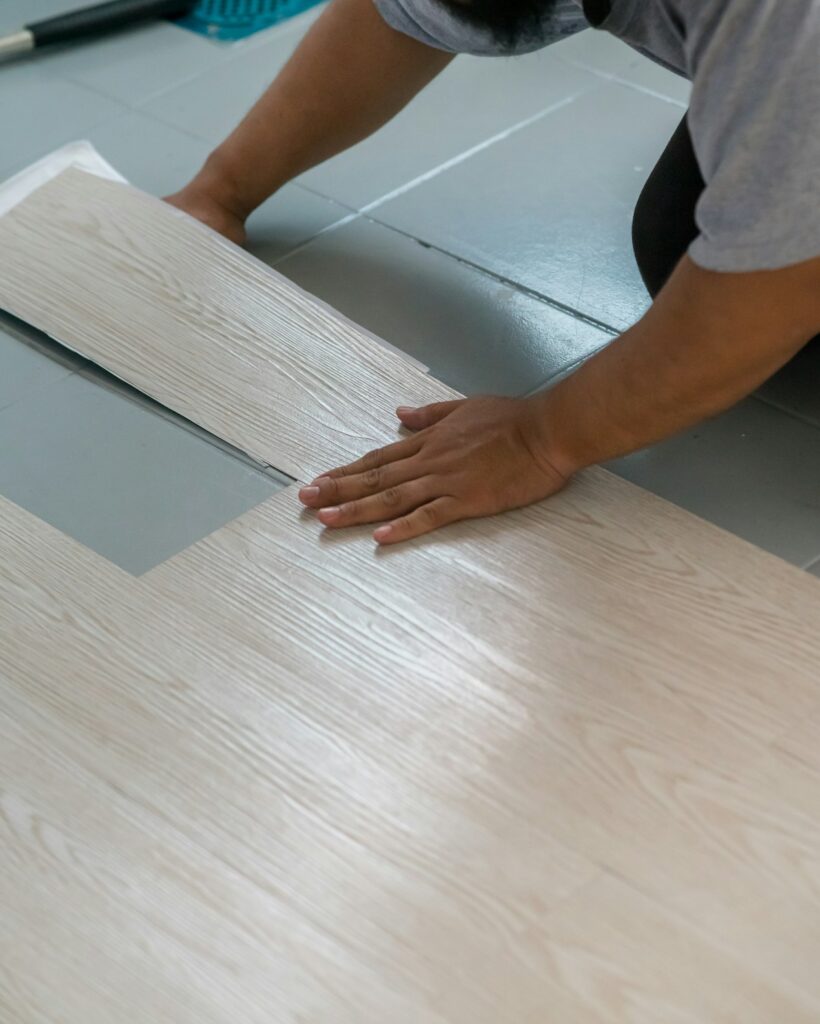 Man installing a vinyl floor. Self-adhesive vinyl flooring.